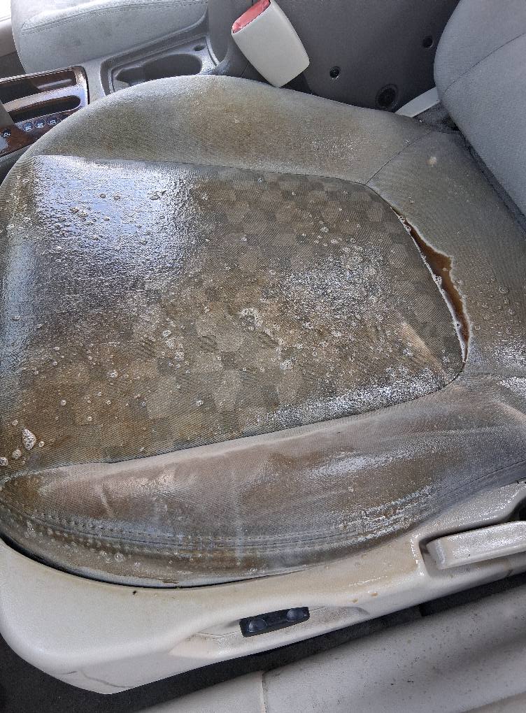 Dirty car seat upholstery with stains before detailing