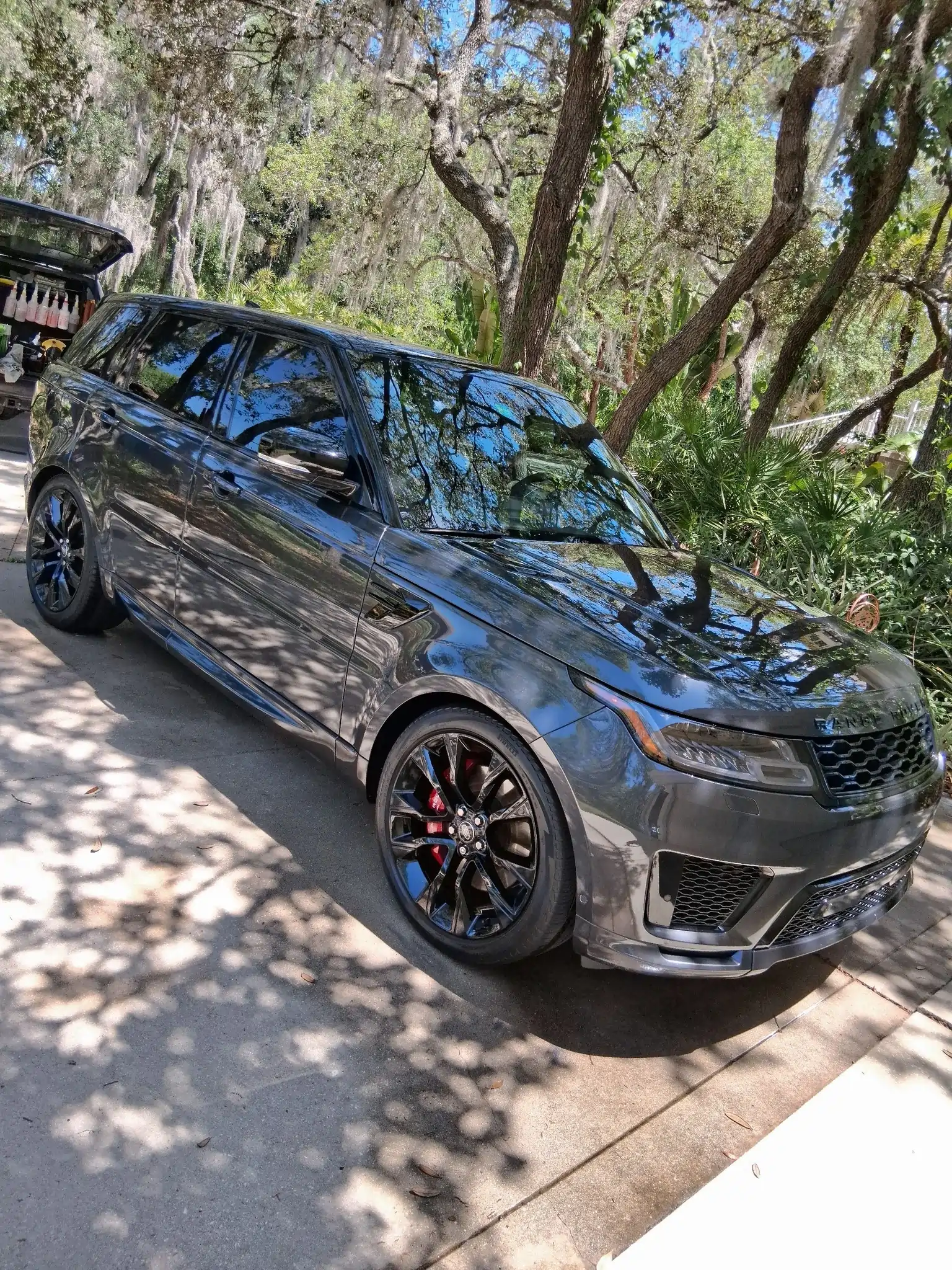 Professional car detailing service on black luxury sports car with glossy ceramic coating finish at Diamond Auto Spa